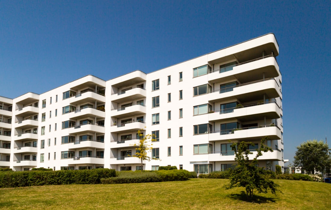 En illustration af en hvid boligblok med altaner.