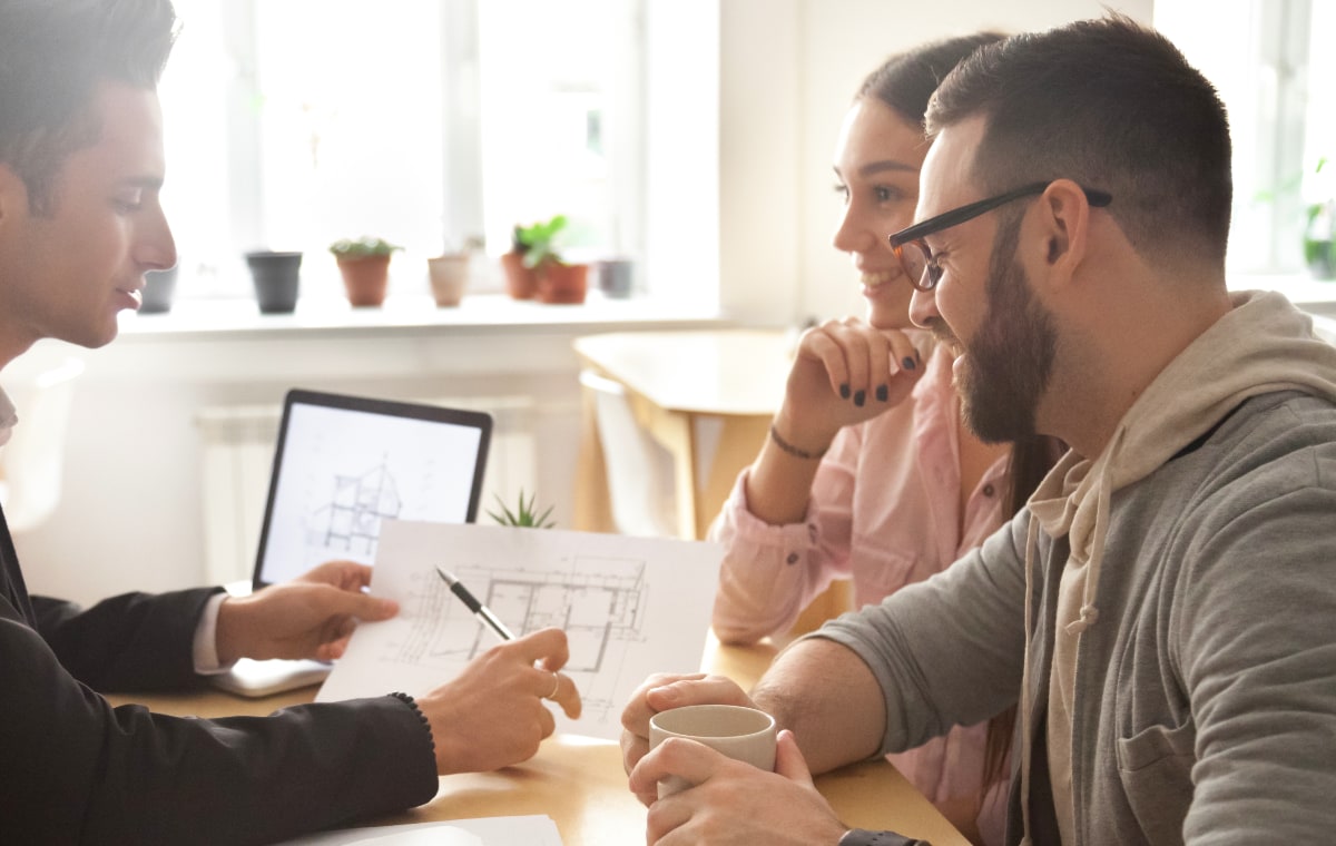 Et par der ser på boligplaner med rådgiver.